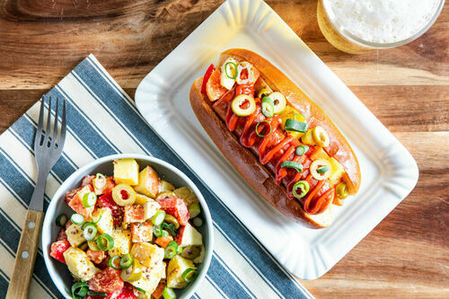 Hotdog mit deftiger Rauchwurst und Kartoffelsalat mit Apfel und Oliven