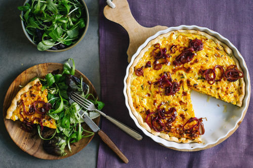 Herbstliche Kürbis-Käse-Quiche mit glasierten Zwiebeln und Salat
