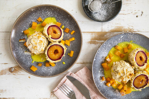 Vegane Pflaumenknödel mit Kokos-Cashew-Panade dazu Vanillesauce und frische Kaki