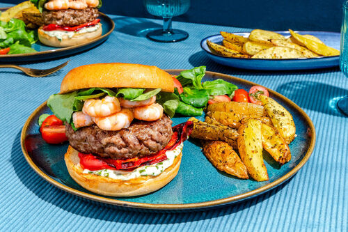 Surf’n’turf-Burger mit Knobi-Pommes dazu Schnittlauchremoulade und Tomatensalat