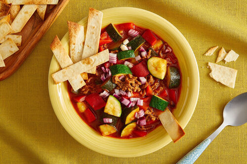 Hackfleisch-Gemüse-Suppe mexikanische Art mit Zwiebeln und High-Protein-Tortillasticks
