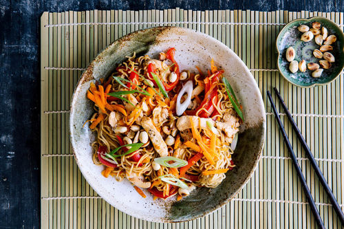 Asia-Hähnchen-Nudelpfanne mit Gemüse und gerösteten Erdnüssen