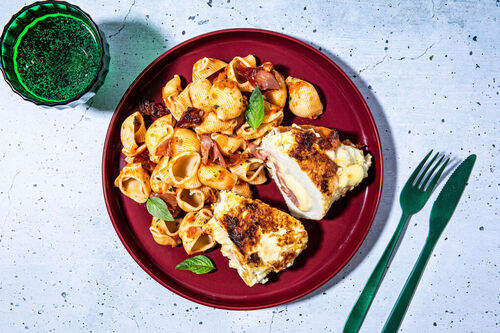 Hähnchen mit Serranoschinken und Käse an Pasta in Paprika-Basilikum-Sauce