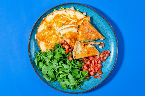 Pfannen-Quesadillas mit geräuchertem Hähnchen dazu eingelegte Tomaten und Rucola