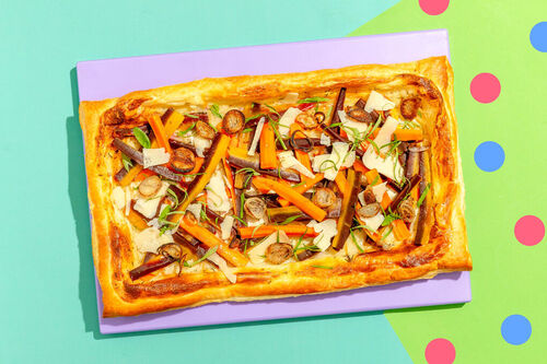 Bunte Karottentarte mit Kräutercreme garniert mit Schalotten und Basilikum