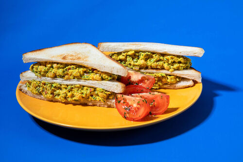 Veganes Doppeldecker-Sandwich mit Kichererbsen-Kapern-Aufstrich und Tomaten