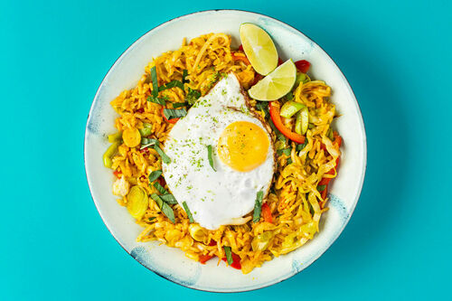 Curry-Gemüsereis und Spiegelei mit frischer Limette und Thai-Basilikum