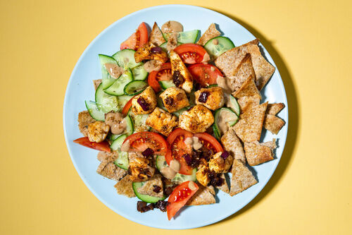 Gebratene Gyros-Hähnchenstücke auf Brotsalat im Fatoush-Style