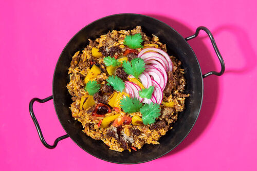 Pikanter Reistopf mit Rinderhack und Käse, dazu eingelegte Zwiebeln