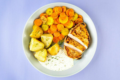 Zartes Schweinesteak mit cremiger Sauce dazu Kartoffeln und glasierte Karotten