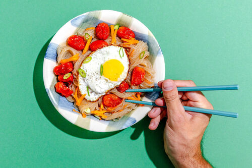 Zwei Spiegeleier auf Glasnudeln mit Kirschtomaten, Karotten und Lauch