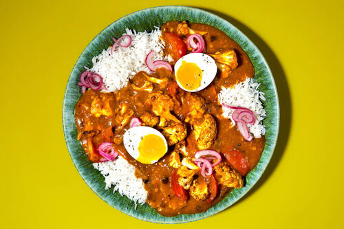 Blumenkohl-Curry mit weichem Ei mit eingelegten Zwiebeln auf Naturreis