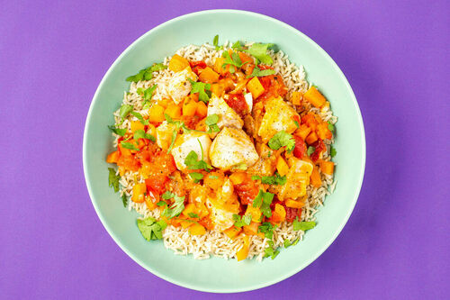 Gemüsepfanne mit Alaska-Seelachs und Koriander an braunem Reis