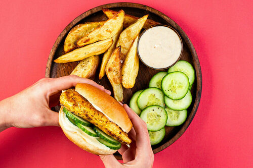 Indischer Veggie-Hähnchenburger mit Kartoffelspalten und würzigem Joghurt