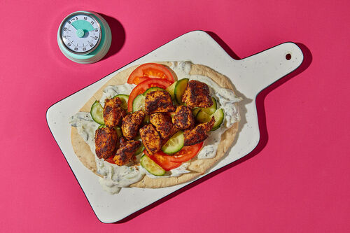 Saftiges Tandoori-Hähnchen auf Naanbrot mit frischem Gemüse und Raita