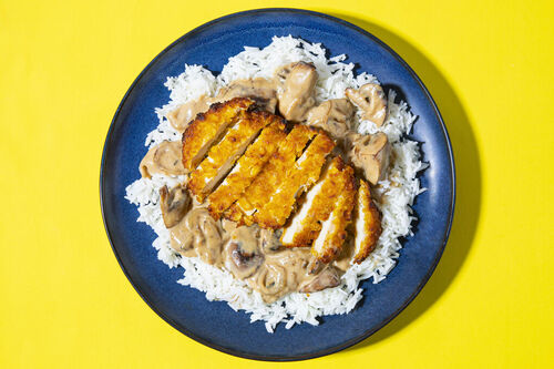 Krosses Hähnchenschnitzel auf Reis mit cremiger Champignonsauce
