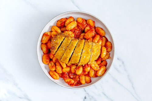 Veganes Knusperschnitzel auf Gnocchi in Tomatensauce