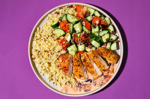 Schweinesteak in Tomaten-Oliven-Sauce auf würzigem Couscous, dazu Gurkensalat