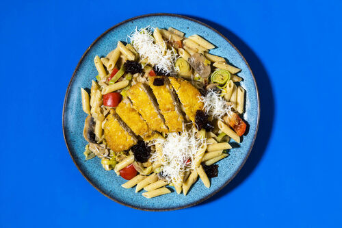 Veggie-Hähnchenschnitzel auf Penne mit buntem Gemüse in cremiger Sauce