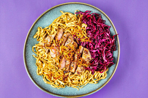 Schweineschnetzel auf Chilinudeln dazu eingelegte Rotkohlstreifen