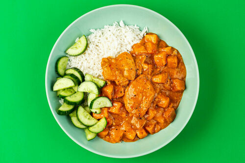 Hähnchen in pikanter Erdnusssauce an Reis und frischem Gurkensalat