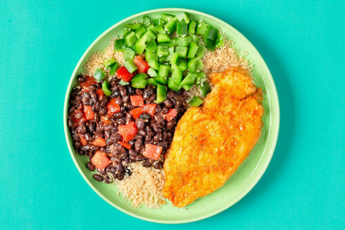 Knuspriges Hähnchen mit schwarzen Bohnen dazu Couscous und grüne Paprika