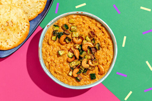 Cremiges Linsen-Kokos-Dal mit Cashews dazu gebackene Zucchini und Pitabrot