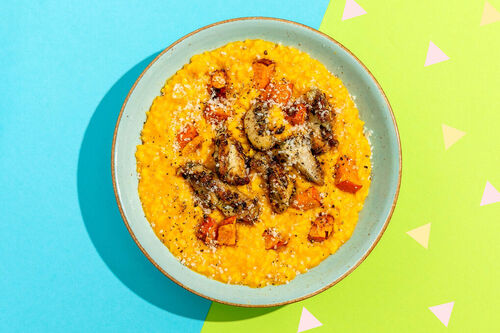 Italienisches Kürbisrisotto mit Hähnchen und Käse garniert