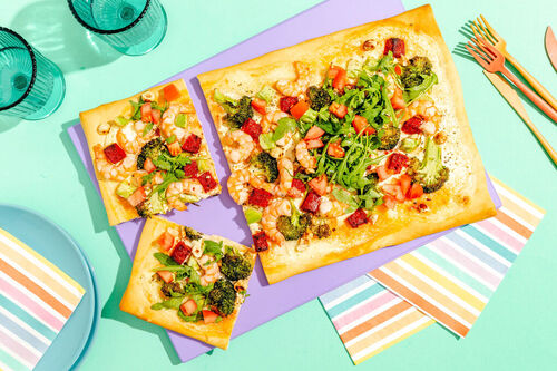 Herzhafte Garnelen-Chorizo-Pizza mit Crème fraîche, Rucola und Haselnusskernen