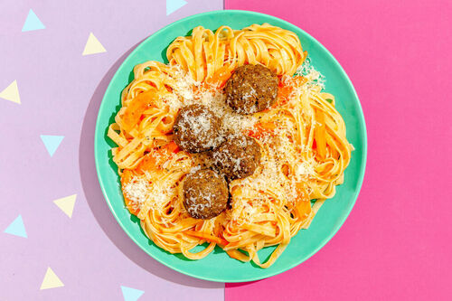 Pasta mit würzigen Fleischbällchen serviert auf frischer Tomatensauce