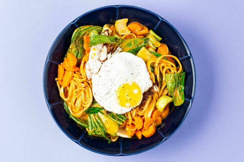 Udon-Nudeln mit Spiegelei und Gemüse in feuriger Curry-Kokos-Sauce