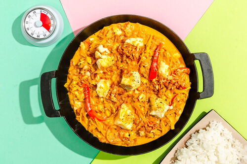Cremiges Thai-Fischcurry mit Gemüse und Röstzwiebeln auf duftendem Jasminreis