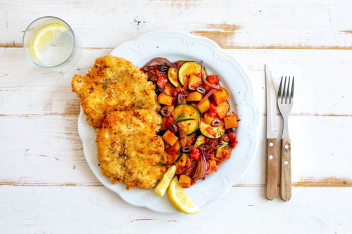 Knusprige Hähnchenschnitzel mit Kartoffeln in Tomatensugo