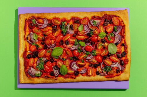 Bunte Tomatenpizza „Marinara“ mit Oliven und Basilikumöl