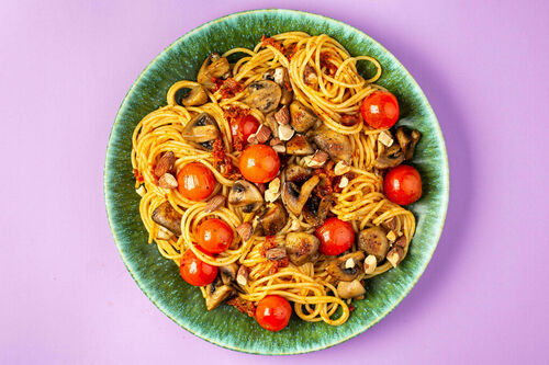 Pesto-Spaghetti mit geschmorten Kirschtomaten dazu Champignons und Rauchmandeln