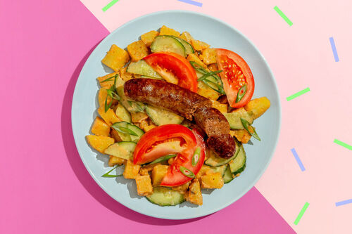 Rindswurst auf buntem Kartoffelsalat mit asiatisch gewürztem Dressing