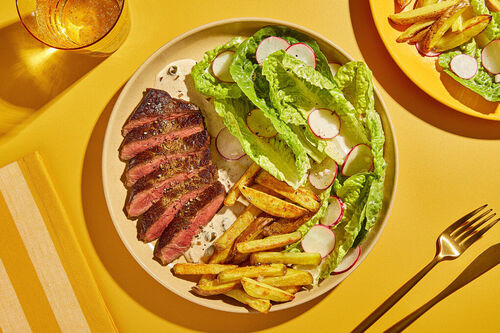 Rindersteak mit Crème fraîche und Kapern serviert mit Ofenkartoffeln und buntem Salat