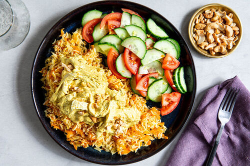 Bio-Hähnchen in cremig-süßer Currysauce mit Karotten-Reis und Tomaten-Gurken-Salat