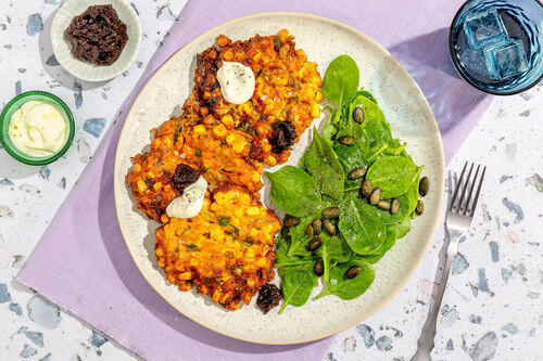 Pikante Mais-Feta-Krapfen Cajun-Style mit Spinatsalat und Grüne-Tomaten-Chutney