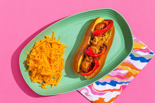 Hotdog mit deftiger Rindswurst mit Zwiebel und Paprika dazu Karottenslaw