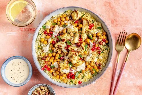 Bulgur-Bowl mit Kichererbsen und Blumenkohl mit Tahinisauce, Granatapfel und Mandeln