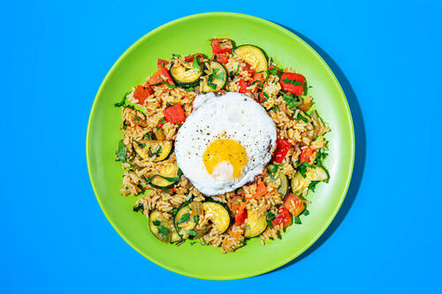 Bunter Bratreis mit Spiegelei und Kräutern mit Zucchini und Tomaten