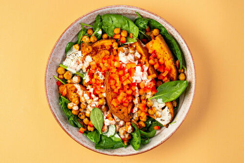 Süßkartoffel-Bowl mit Crème fraîche darin Kichererbsen und buntes Gemüse