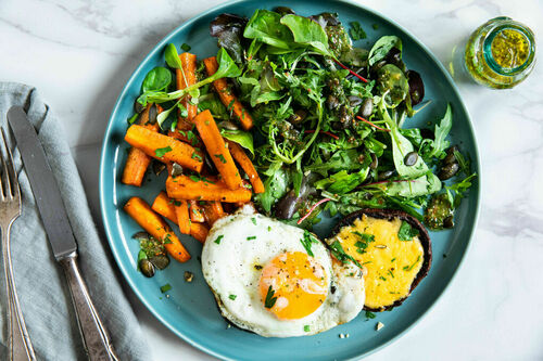 Spiegeleier auf Portobello-Pilzen mit Käse an Salat mit Schnittlauch und Kürbiskernen