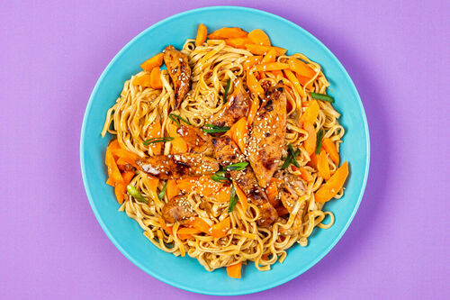 Asia-Schweinegeschnetzeltes mit Mie-Nudeln mit Karotten und weißem Sesam