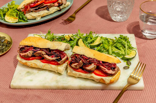 Bio-Steak-Sandwich mit Blauschimmelkäsesauce mit Tomaten, Zwiebeln und Zucchinisalat