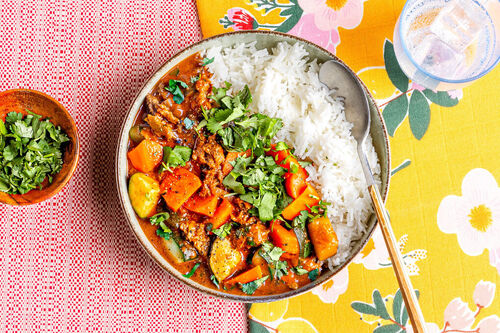 Westafrikanischer Erdnusseintopf mit Gemüse und Koriander auf Basmatireis