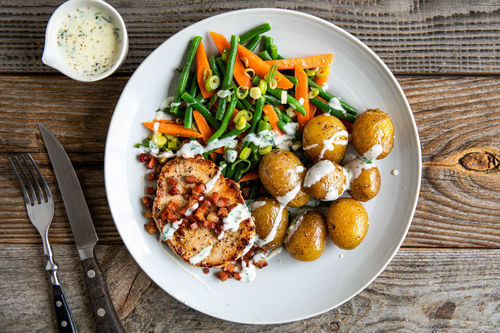 Schweinesteak mit knusprigem Bacon dazu grüne Bohnen, Kartoffeln und Sauce