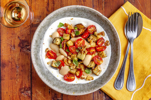 Gebackenes Auberginengemüse mit Bohnen auf Zitronenjoghurt mit Walnusskernen