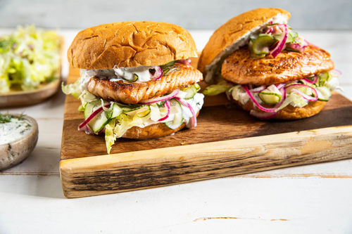 Lachsburger mit Remoulade und eingelegten Zwiebeln, dazu Salat